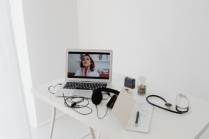 A virtual healthcare consultation via laptop with medical equipment on a minimalist desk.
